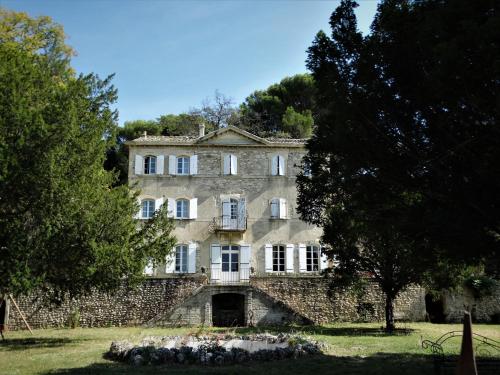 una vieja casa de piedra con árboles delante de ella en Château MontPlaisir charming b&b in Provence en Valréas