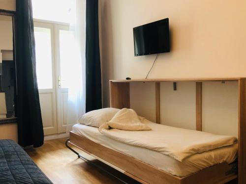 a bedroom with a bed and a tv on the wall at Modern cozy apartment in central Prague in Prague