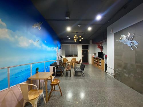 a dining room with a blue wall and a table and chairs at Xinshe Hotel - Hsinchu in Hsinchu City