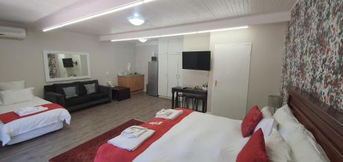 a hotel room with two beds and a living room at Acacia Westdene B&B in Bloemfontein