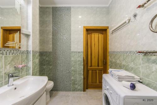 a bathroom with a sink and a washing machine at Kiev Lodging in Kyiv