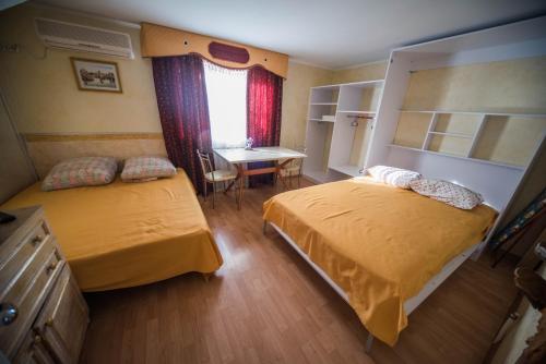 a bedroom with two beds and a table and a desk at Holiday Home near sea in Odesa