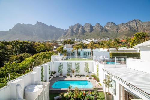 a house with a swimming pool and mountains in the background at Funkey Villas Cape Town in Cape Town