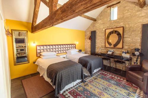 a bedroom with two beds and a dining room with a table at T's at Lower Rudloe Farm in Corsham