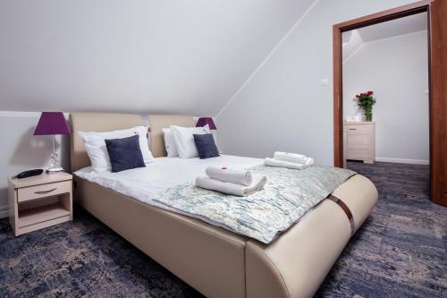 a bedroom with a large bed with towels on it at Hotel Trzy Róże in Lublin