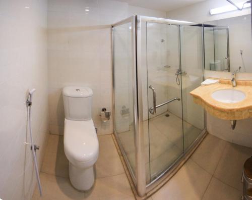 a bathroom with a shower and a toilet and a sink at Muscat Inn Hotel in Muscat