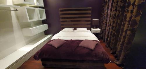 a small bedroom with a bed with purple walls at Fontaine in Geneva