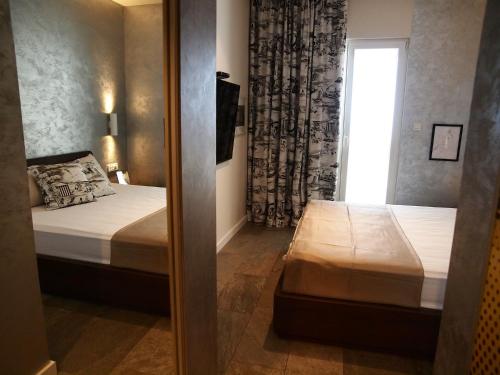 a small room with two beds and a window at Apartments House Filipović in Makarska