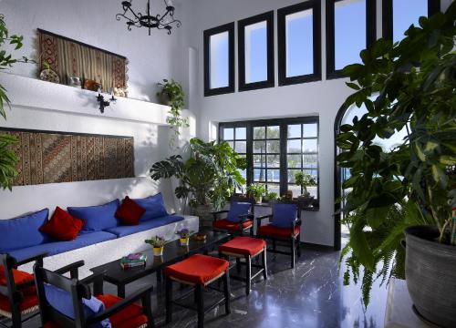 a living room with a blue couch and red chairs at Victoria Hotel in Agios Nikolaos