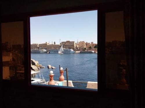a window with a view of a river with a boat at El-amin Guest House in Aswan