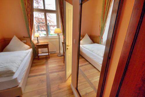 a small room with two beds and a window at Das Schloss Burgellern - Genuss und Geschichte seit 1726 in Scheßlitz