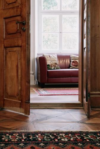 a living room with a couch and a window at Das Schloss Burgellern - Genuss und Geschichte seit 1726 in Scheßlitz
