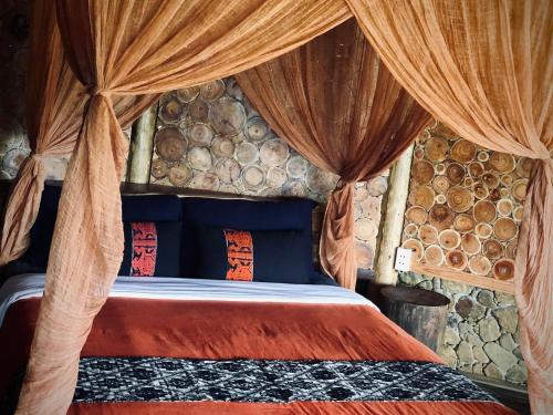 a bedroom with a bed in a room with logs at Lua Pu Luong in Pu Luong