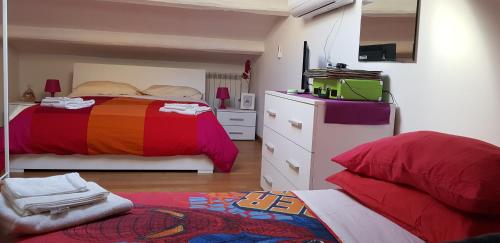a bedroom with a bed and a dresser with a colorful blanket at Casa Garofoli in Frascati