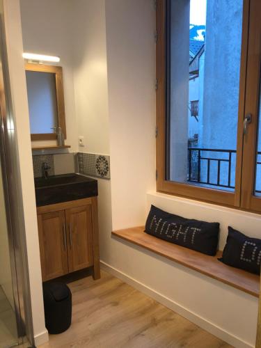 een badkamer met een raam met een wastafel en een aanrecht bij La maison de la montagne in Le Bourg-dʼOisans