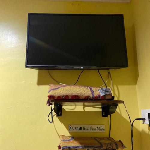 een flatscreen-tv aan een muur bij Hotel Rembau in Rembau