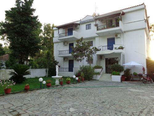 a large white building with a stone driveway at Porto Kairis in Oreoí