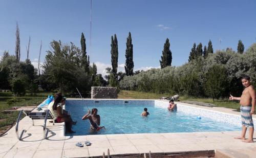 Chalecito Campestre Centrico في مالارغي: مجموعة من الناس يلعبون في حمام السباحة