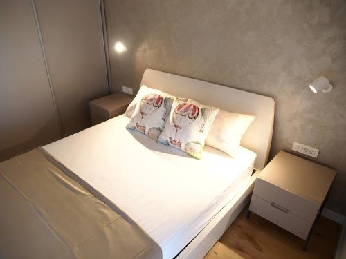 a small bedroom with a bed with two pillows at Apartments House Filipović in Makarska