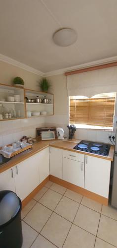 a kitchen with white cabinets and a counter top at Acacia Westdene B&B in Bloemfontein