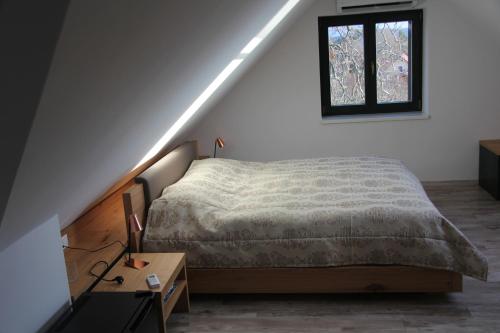 a bedroom with a bed and a window on the wall at Éliás Borbirtok in Badacsonytomaj