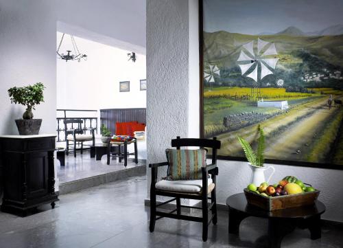 een kamer met stoelen en een schilderij aan de muur bij Victoria Hotel in Agios Nikolaos
