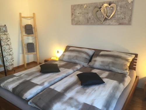 a bed with two pillows on it in a room at Lake View Apartment in Faulensee