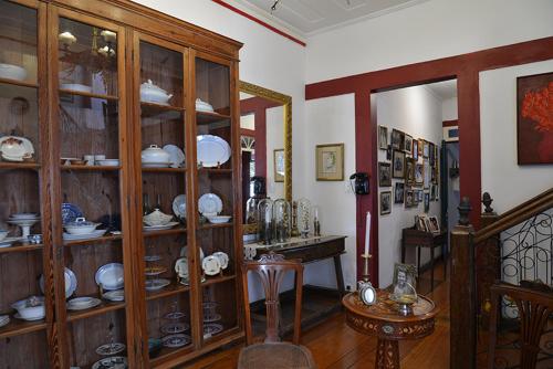 um quarto com prateleiras de madeira cheias de porcelana em Pousada Guignard em Ouro Preto