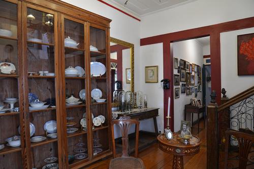 a room with wooden shelves filled with china at Pousada Guignard in Ouro Preto