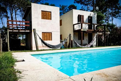 una casa con piscina frente a una casa en Achalay, en Punta del Diablo