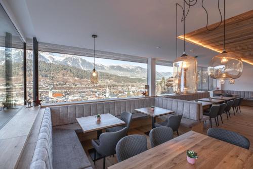 a restaurant with tables and chairs and a large window at Rohrmooser Schlössl in Schladming