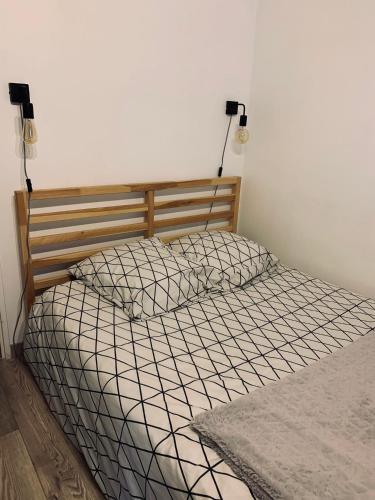 - un lit dans une chambre avec deux lumières sur le mur dans l'établissement Cosy Flat Cherbourg, à Cherbourg en Cotentin