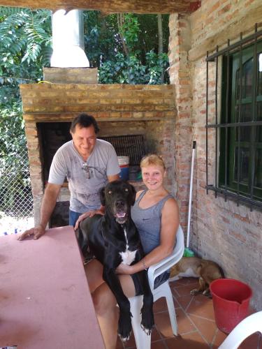 a man and a woman sitting at a table with a dog at Cuatro Estaciones in General Rodríguez