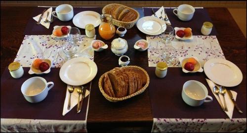 une table avec des assiettes et des ustensiles dessus dans l'établissement L'Apothéis, à Saint-Thégonnec