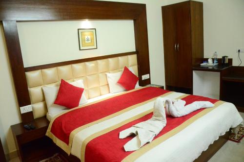 a bedroom with a large bed with red pillows at Hotel Milam Inn in Almora