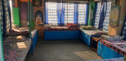 a room with three beds in a train at Milkman Guest House in Pushkar