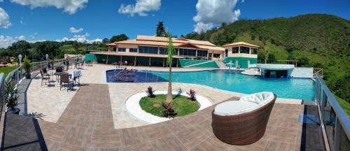 a resort with a swimming pool and a house at Fazenda Morro Pelado in Águas de Lindóia
