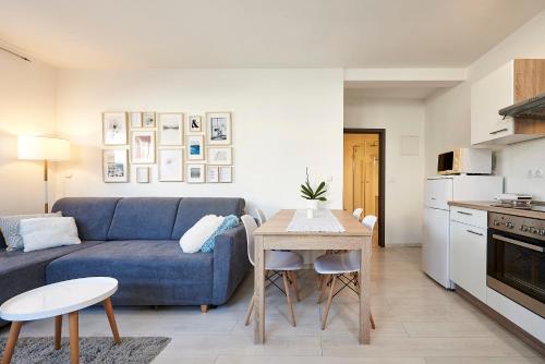 - un salon avec un canapé bleu et une table dans l'établissement Apartmani Sara i Klara, à Trogir