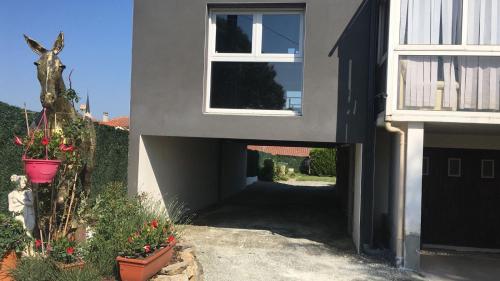 a black and white house with a door and flowers at Gite Au Cheval D'or in La Meilleraie-Tillay