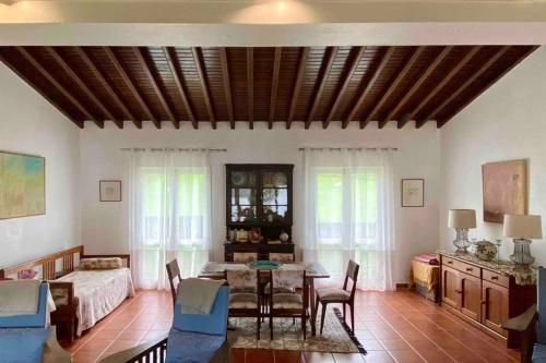 a living room with a table and chairs and a bedroom at Lake Cottage - Panoramic views 7 Cidades in Sete Cidades