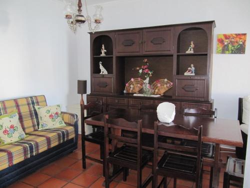 a dining room with a desk and a table and a couch at Foz Beach House in Buarcos