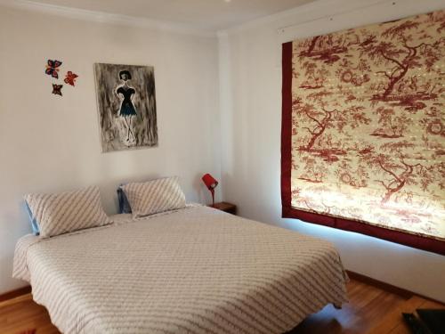 - une chambre avec un lit et une peinture murale dans l'établissement Studio Telheiras 2, à Lisbonne