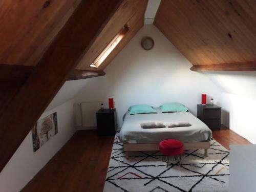 une chambre avec un lit dans un grenier dans l'établissement L'escale Arquaise, la maison au jardin fleuri à 5 min de dieppe, à Arques-la-Bataille