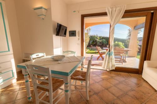 uma cozinha e sala de jantar com mesa e cadeiras em Poggio dei fiori em Olbia