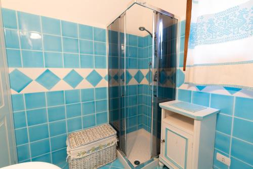 uma casa de banho com um chuveiro com azulejos azuis em Poggio dei fiori em Olbia