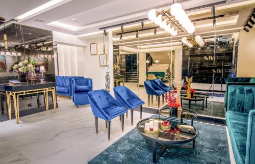 a lobby with blue chairs and a table at Hotel Wilder Mann in Rückersdorf