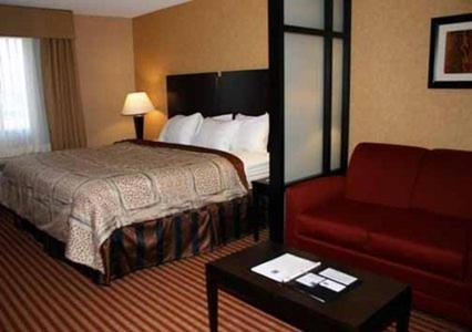 a hotel room with a bed and a red couch at Quality Inn in Dunkirk