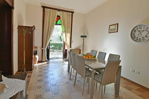 a dining room with a table and chairs and a clock at Villa Siciliana in Taormina