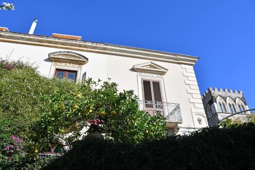 an orange tree in front of a white building at Villa Siciliana in Taormina