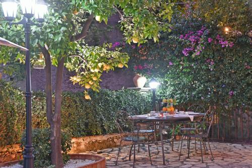 a table and chairs in a garden with a tree at Villa Siciliana in Taormina